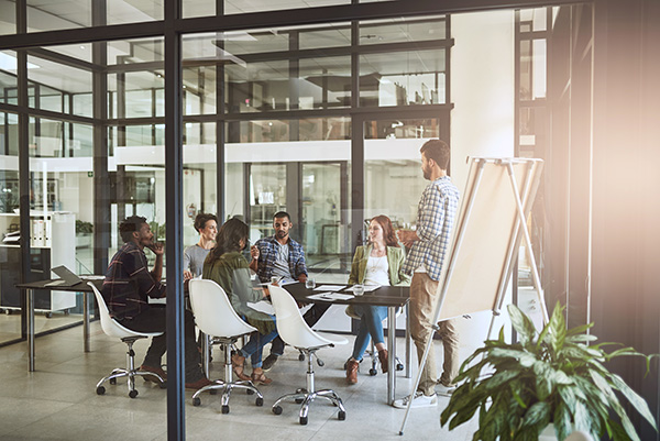 Sechs Personen befinden sich in einem Besprechungsraum in einem modernem Büro – Beitrag zu Unterschied zwischen quantitativer und qualitativer Marktforschung